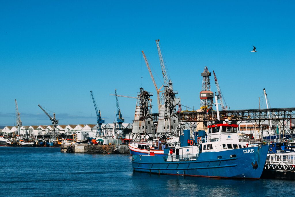 pexels-photo-5800228-5800228 Industrial dock with contemporary cranes and moored cargo vessels in blue water in sunlight